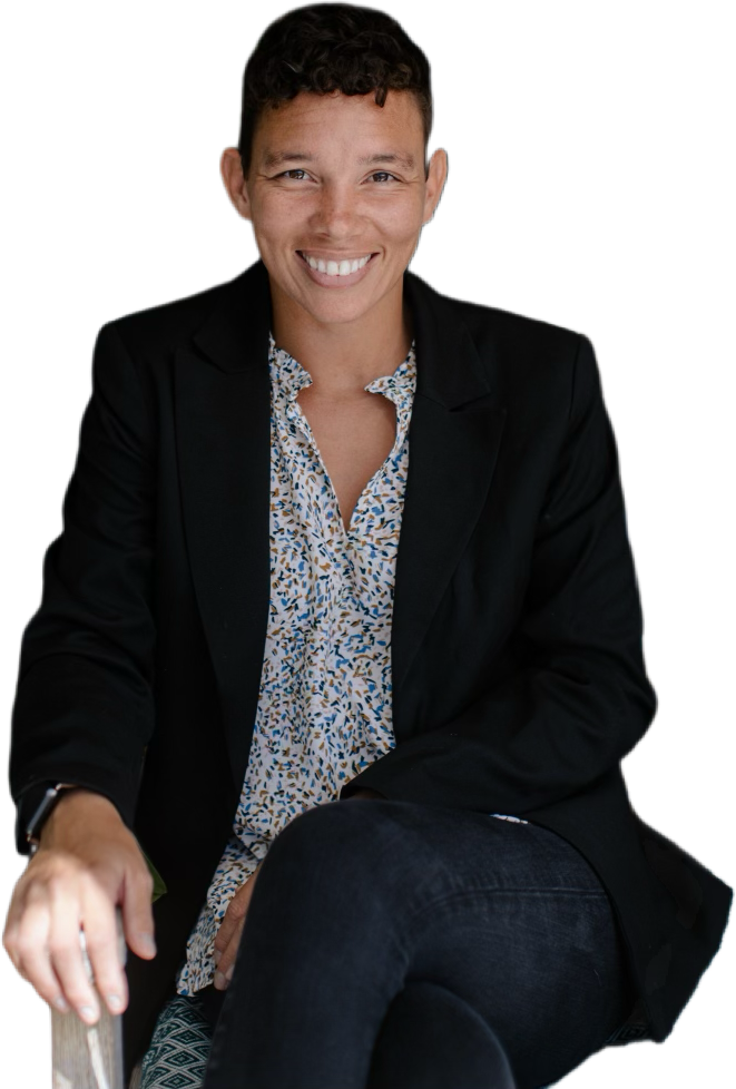 image of biracial woman with short hair, black blazer and pants, blue and white dotted shirt, seated